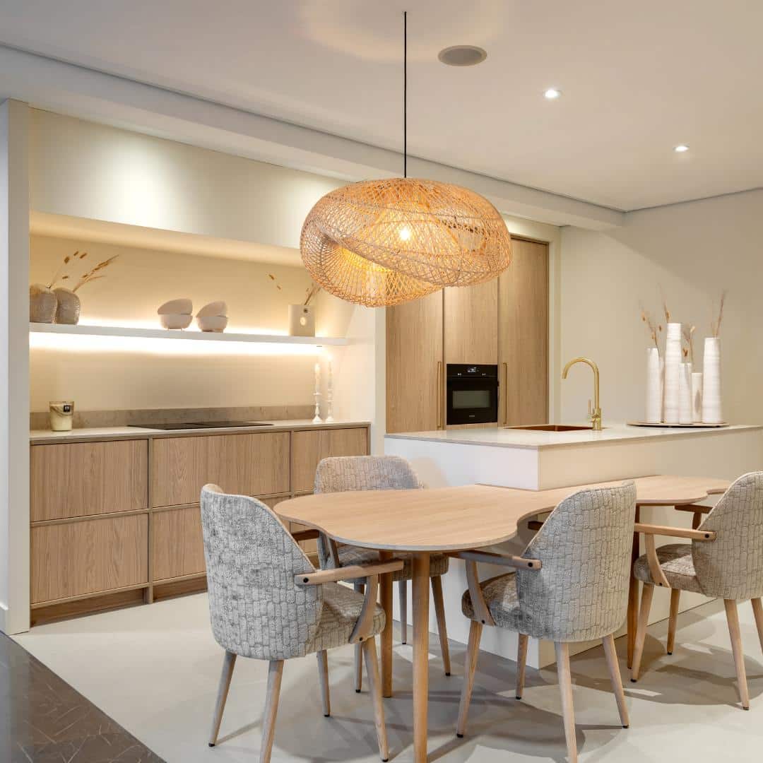 Impressie van een Japandi keuken, voorzien van een eettafel en lamp met organische vormen.