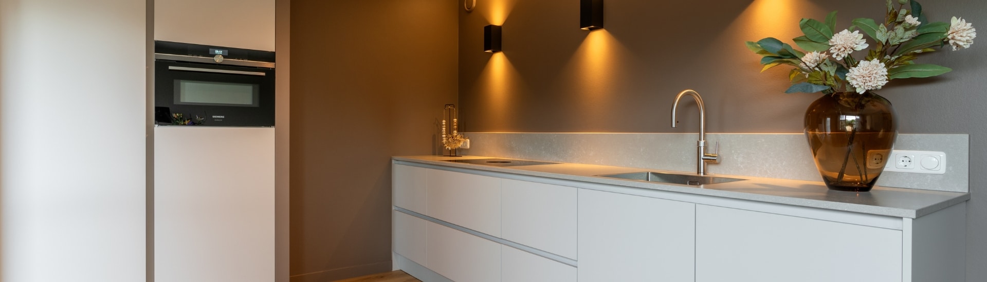 Een strakke minimalistische witte keuken in Nijkerk