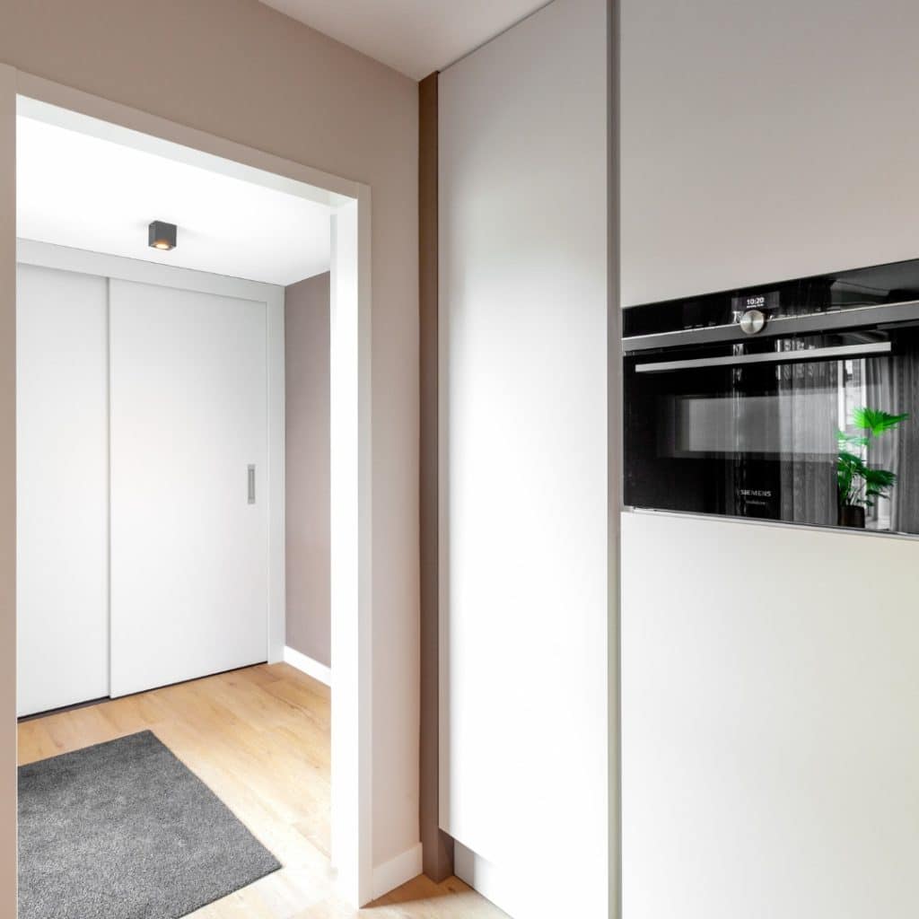 Gestroomlijnde minimalistische keuken met hoge kasten in mat wit en geïntegreerde apparatuur van Siemens Gestroomlijnde minimalistische keuken met hoge kasten in mat wit en geïntegreerde apparatuur van Siemens