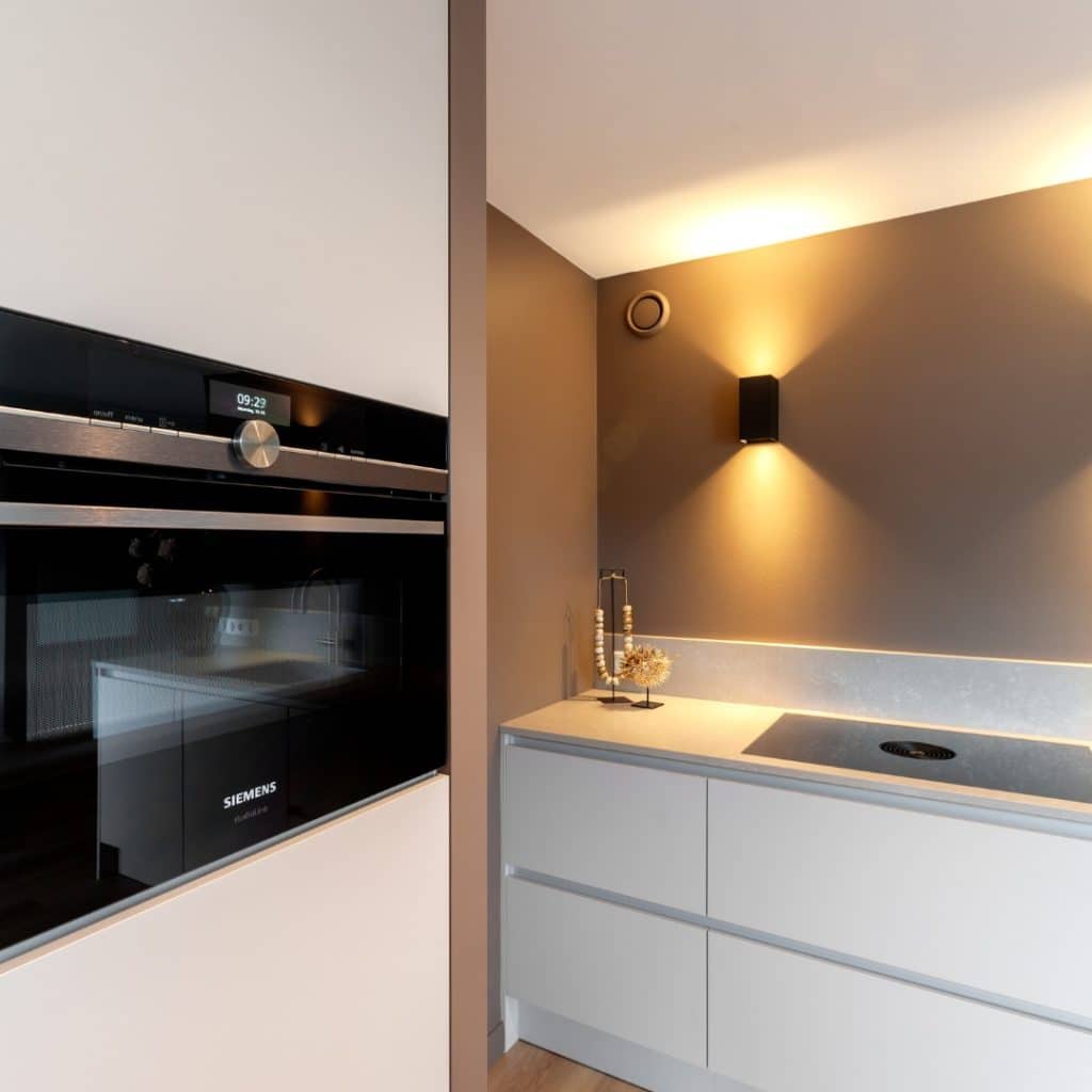Moderne keuken met een naadloos geïntegreerde Siemens keukenapparatuur in een witte kastwand Moderne keuken met een naadloos geïntegreerde Siemens keukenapparatuur in een witte kastwand