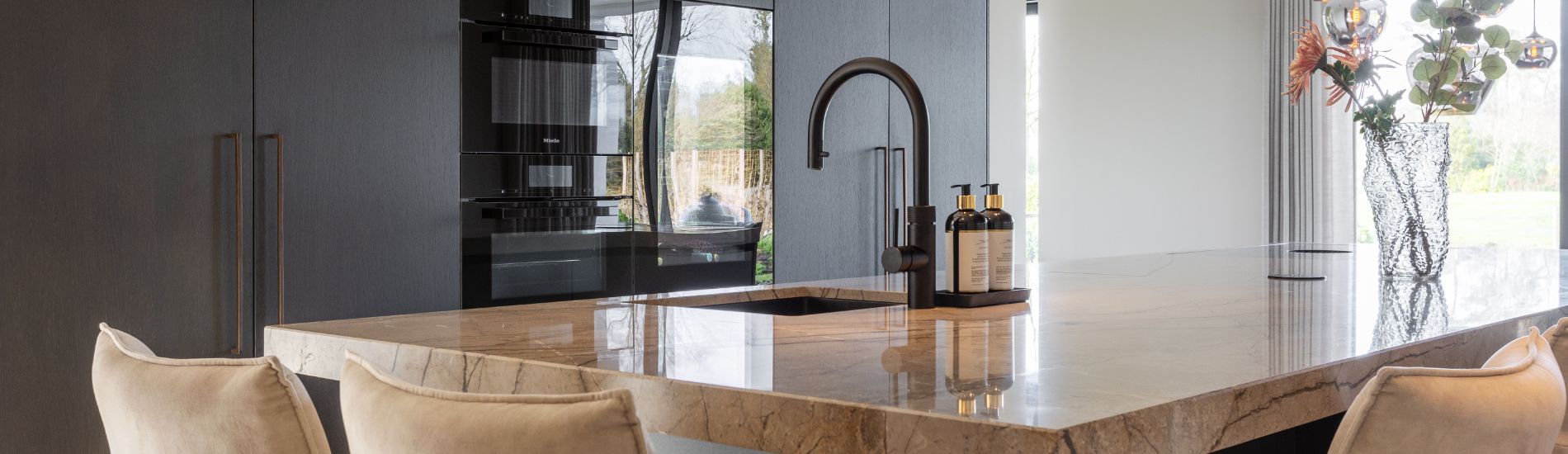 Luxe Fenix keuken in mat zwart, voorzien van kookeiland met marmer blad