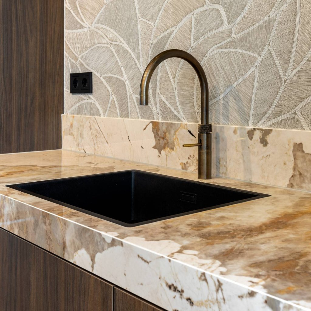 Dekton khalo aanrechtblad met matzwarte wasbak en koperkleurige wastafelkraan.