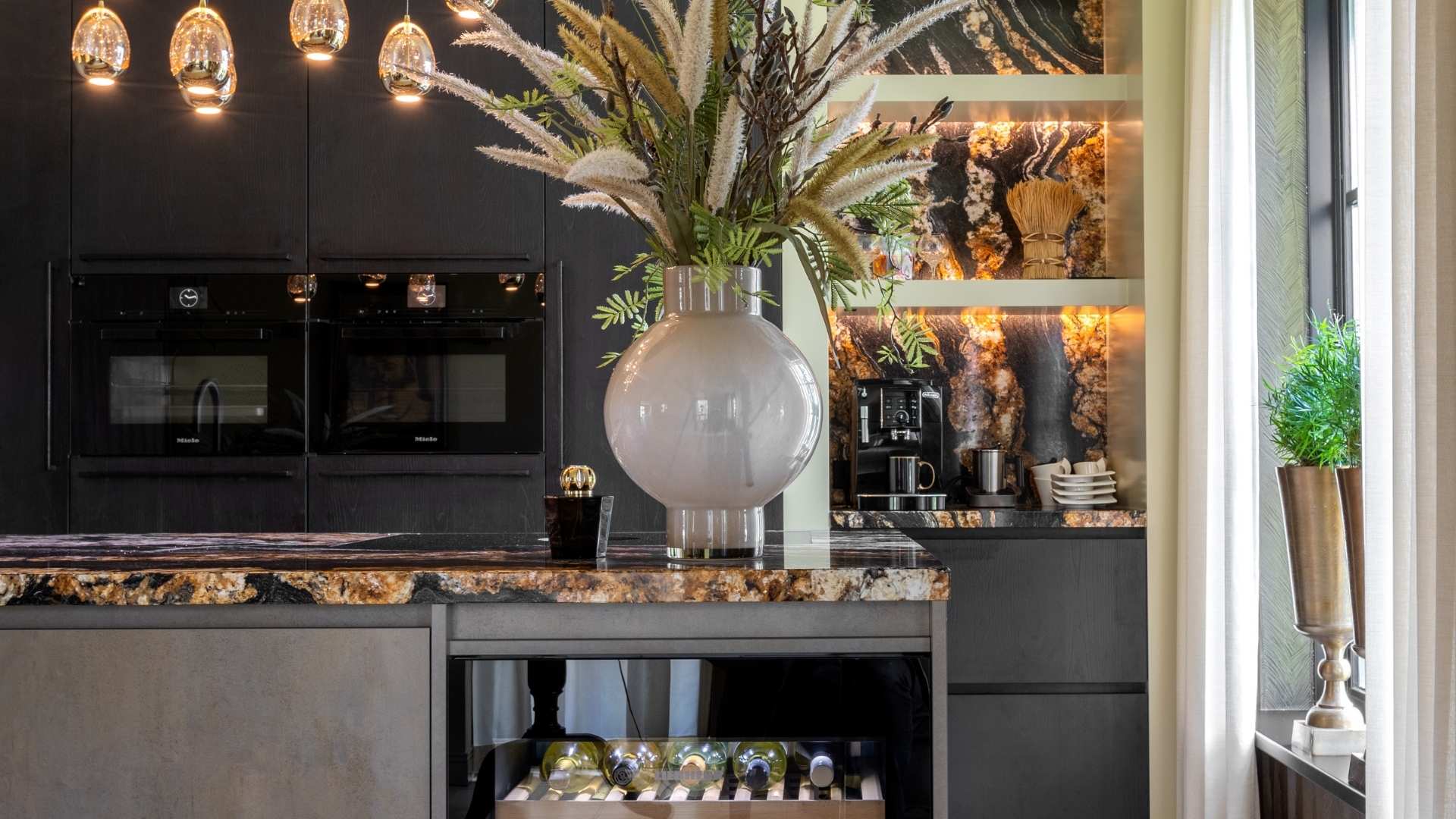 Impressie van een trendy luxe keuken met eiland, voorzien van bronzen accenten en een werkblad in aardse tinten.