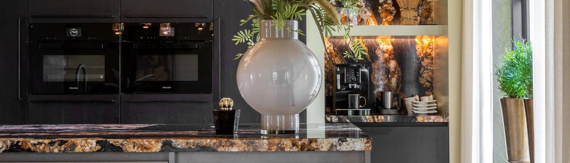 Impressie van een trendy luxe keuken met eiland, voorzien van een werkblad in aardse tinten.