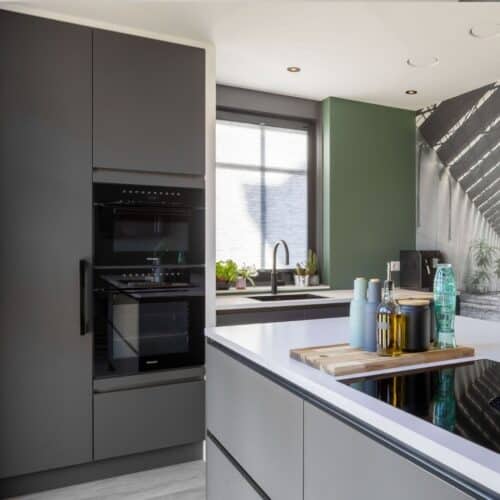 Moderne keuken met zwarte kast en Miele keukenapparatuur in Woudenberg.