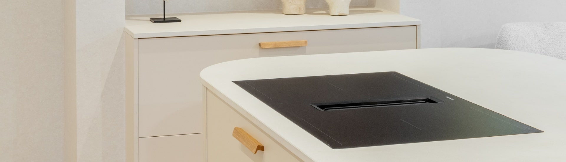 Impressie van een witte Japandi keuken met rondingen, voorzien van een eiland met ronde hoeken.