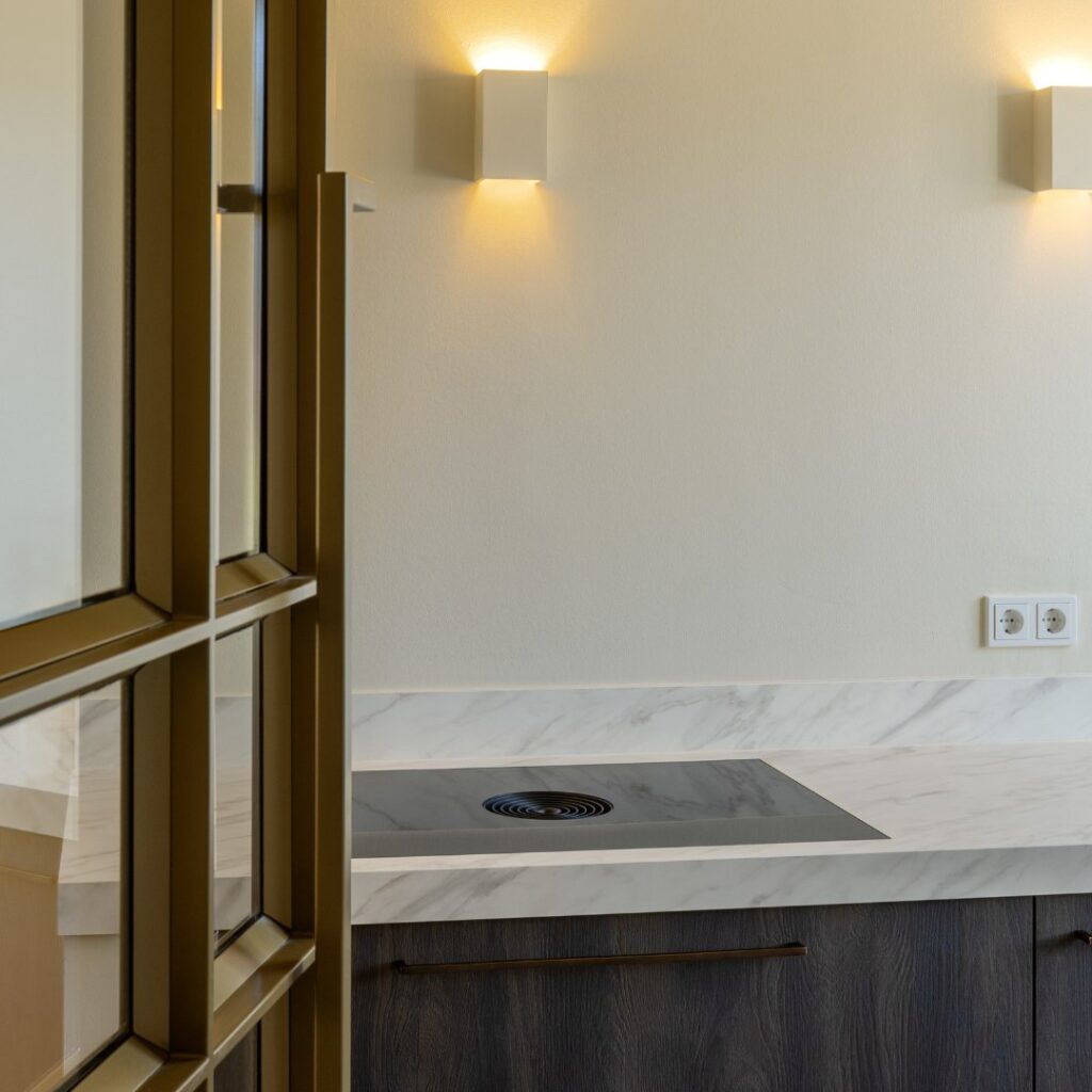 Binnenkomst bij een Hotel Chique keuken, voorzien van een kookplaat met werkbladafzuiging.