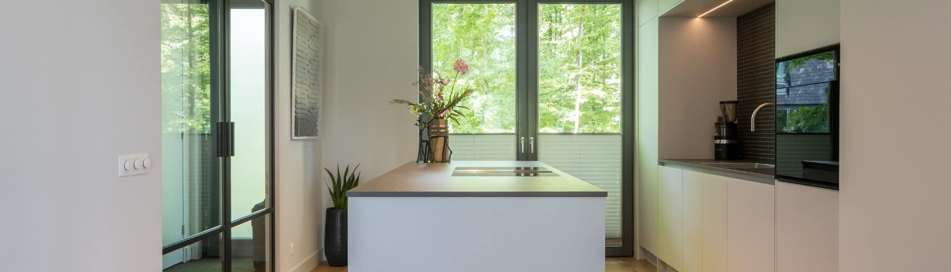 Impressie van een strakke moderne keuken met nis en kookeiland.